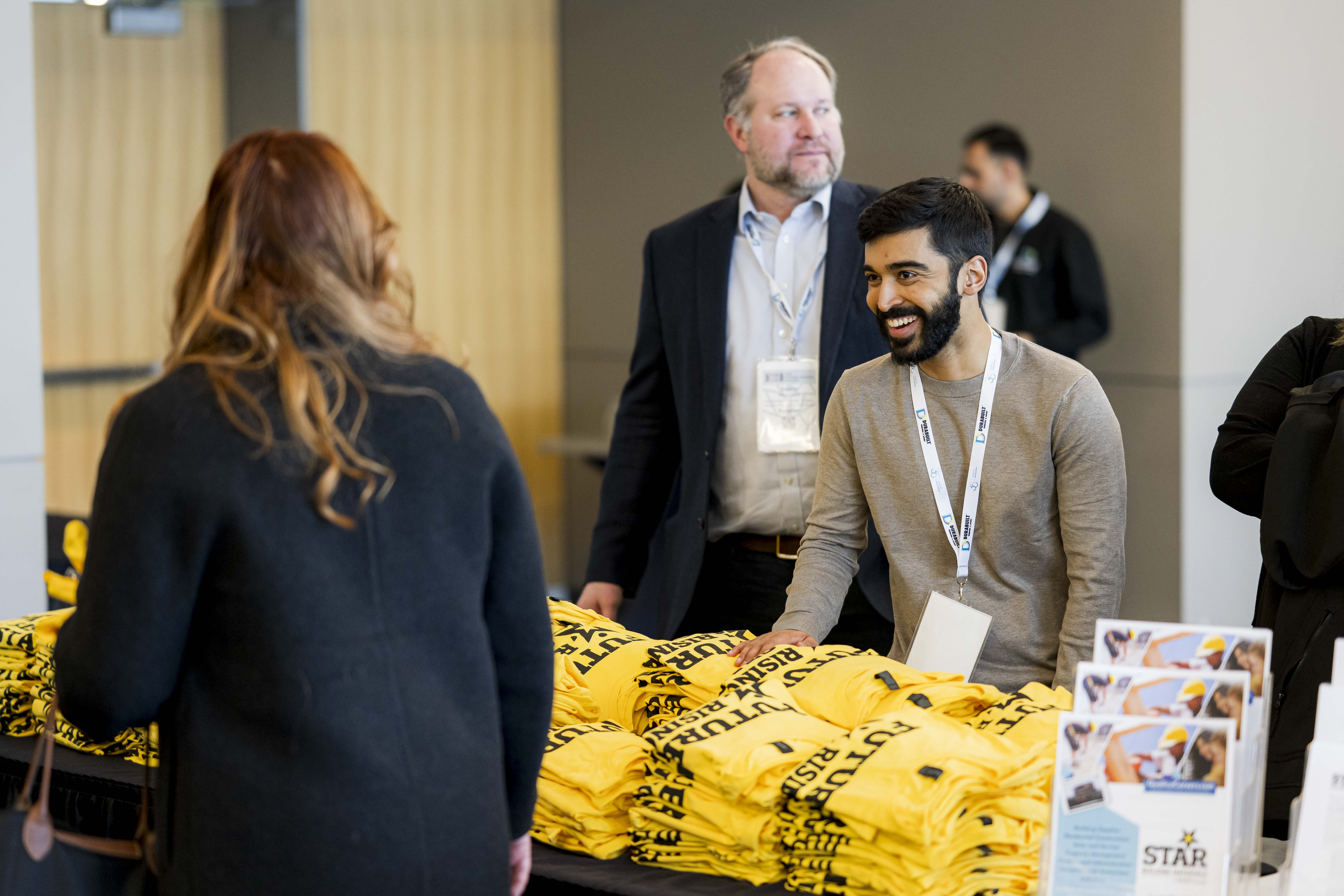 Photo of a friendly Star Building Materials employee talking to an attendee at the 2025 Building and Hardware Showcase Career Fair